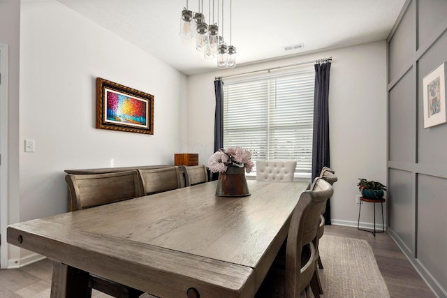 dining area featuring hardwood / wood-style flooring and an inviting chandelier