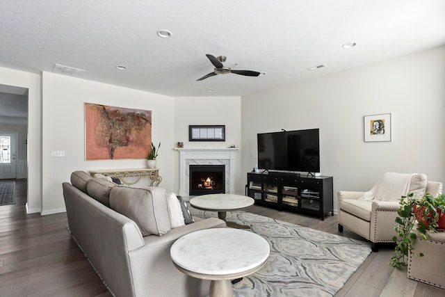 living room featuring a premium fireplace, ceiling fan, and hardwood / wood-style floors