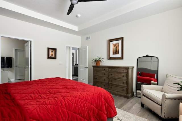 bedroom featuring ensuite bathroom, light wood-type flooring, and ceiling fan