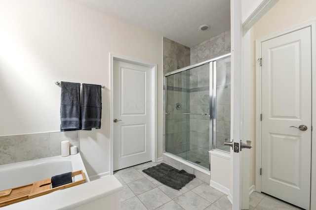 bathroom featuring tile patterned flooring, shower with separate bathtub, and a textured ceiling