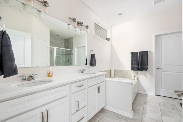 bathroom featuring shower with separate bathtub, vanity, and tile patterned floors