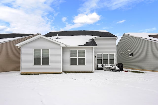 view of snow covered back of property