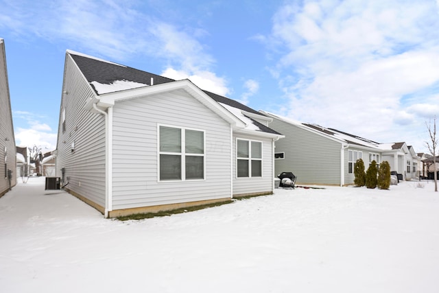 snow covered property featuring central AC unit