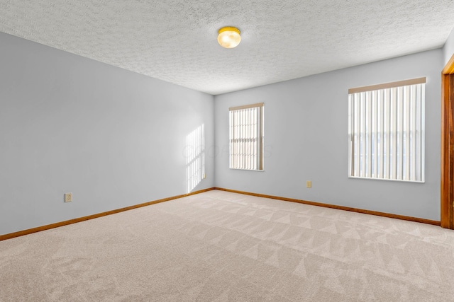 unfurnished room with a textured ceiling and carpet