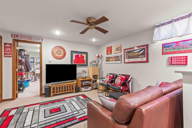 living room with light carpet, ceiling fan, and a textured ceiling