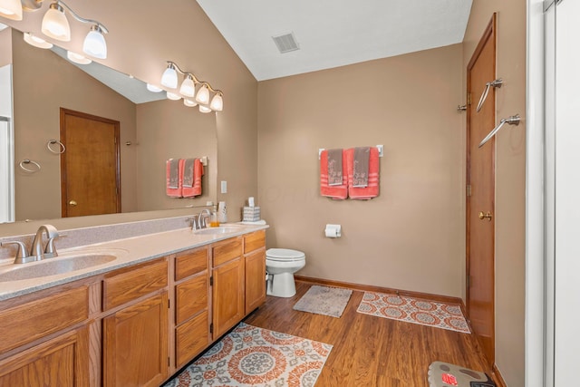 bathroom with toilet, vanity, and hardwood / wood-style flooring