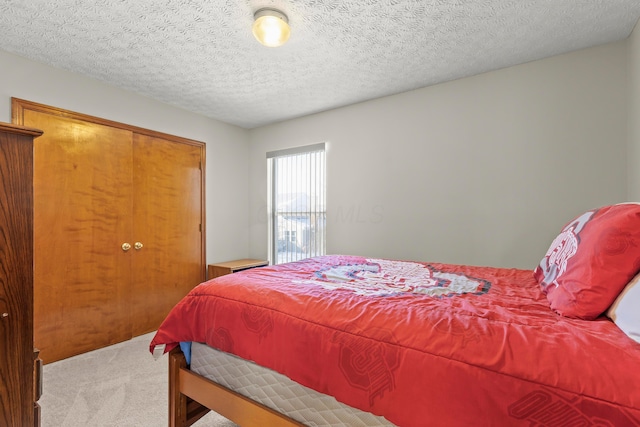 carpeted bedroom featuring a closet and a textured ceiling