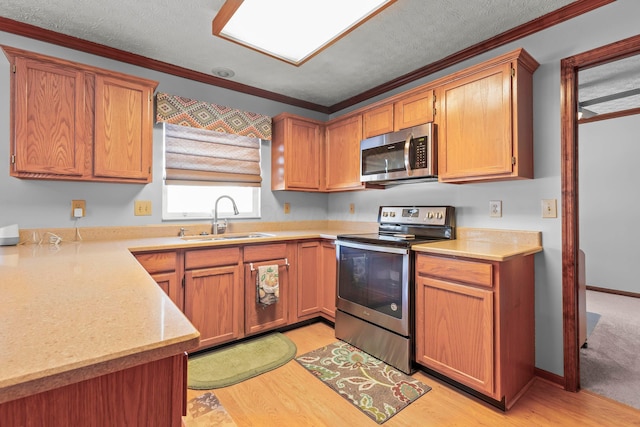 kitchen featuring a textured ceiling, stainless steel appliances, light hardwood / wood-style floors, crown molding, and sink