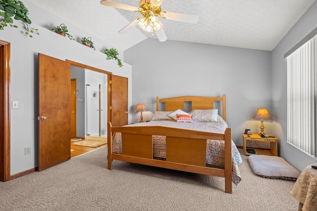 bedroom with a textured ceiling, ceiling fan, vaulted ceiling, and light colored carpet