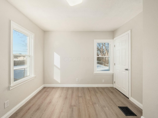 unfurnished room with a healthy amount of sunlight and light wood-type flooring