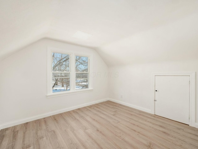 bonus room featuring lofted ceiling and light wood-type flooring