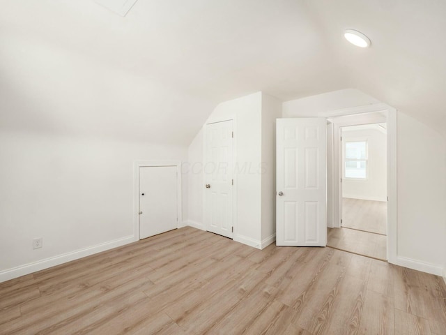 bonus room featuring vaulted ceiling and light hardwood / wood-style flooring