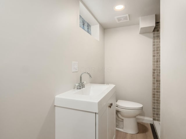 bathroom featuring toilet, hardwood / wood-style flooring, and vanity