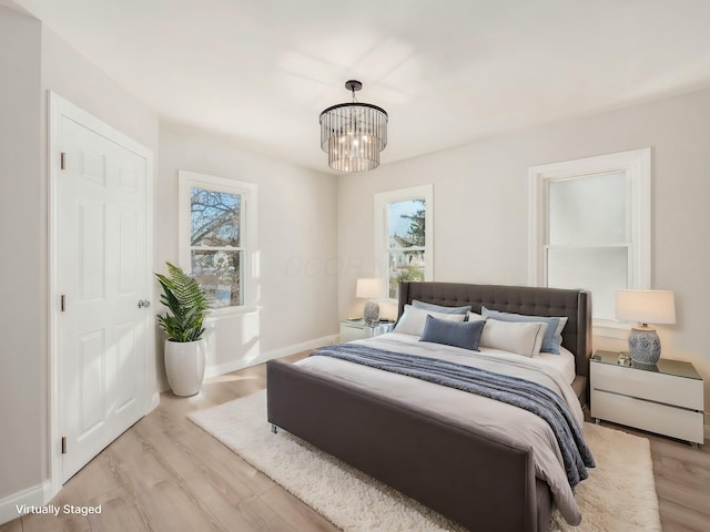 bedroom featuring a notable chandelier and light hardwood / wood-style flooring