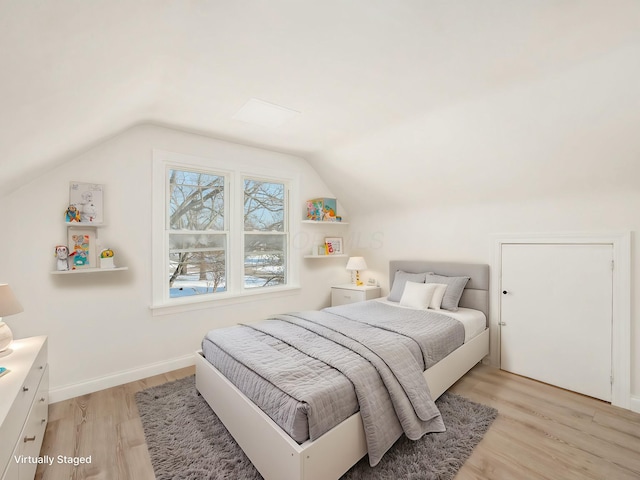 bedroom with vaulted ceiling and light hardwood / wood-style floors