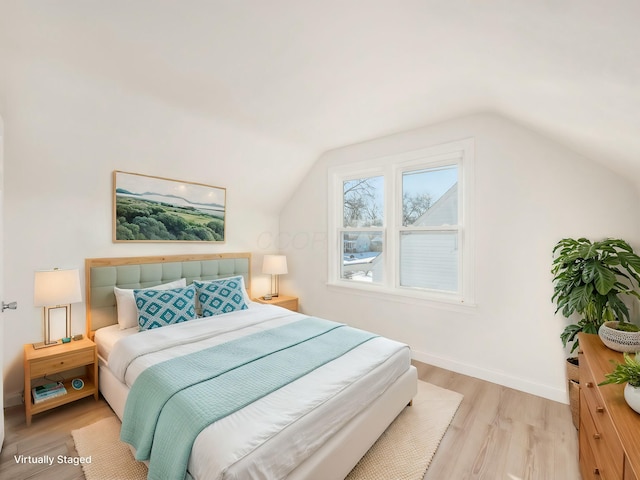 bedroom featuring lofted ceiling and light hardwood / wood-style flooring