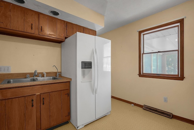 kitchen featuring sink and white fridge with ice dispenser