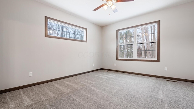 carpeted spare room featuring ceiling fan