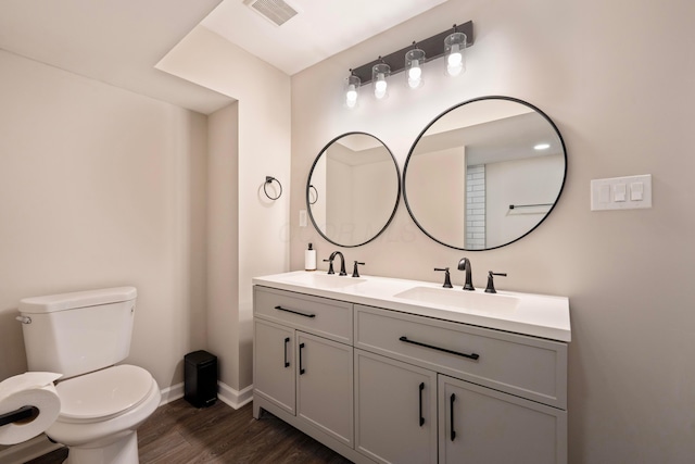 bathroom with toilet, vanity, and hardwood / wood-style floors