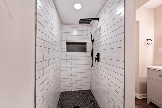 bathroom featuring a tile shower and vanity