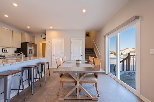 dining room with light hardwood / wood-style flooring and sink