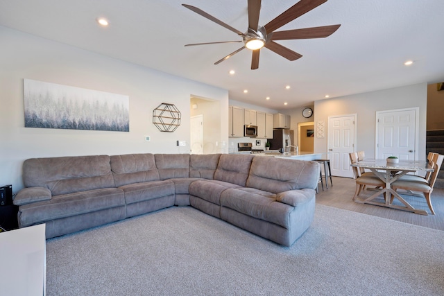 living room with light carpet and ceiling fan