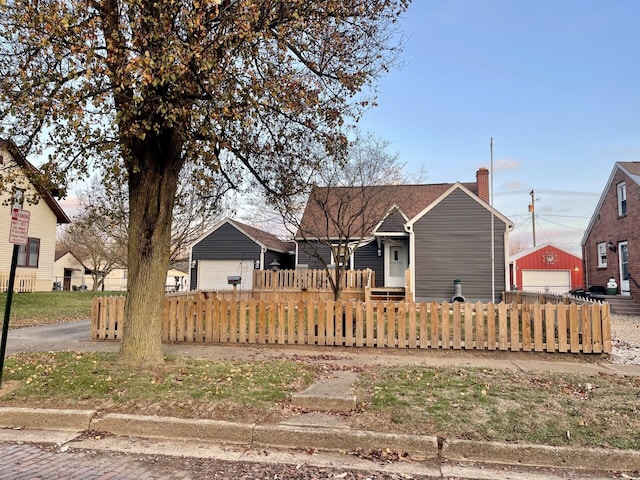 bungalow-style home featuring a garage and an outbuilding