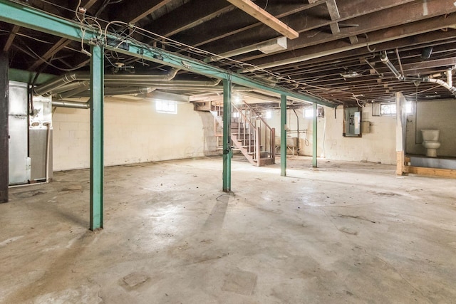 basement featuring electric panel and heating unit