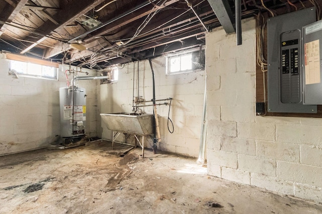 basement featuring sink, water heater, a healthy amount of sunlight, and electric panel