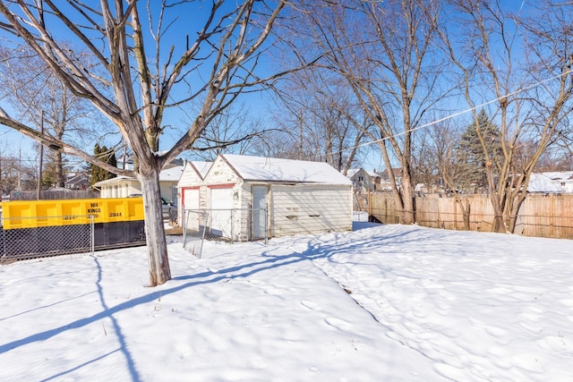 yard covered in snow with a garage and an outbuilding