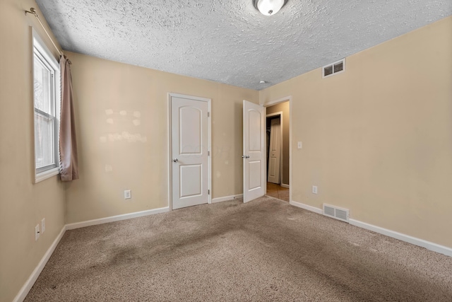 unfurnished bedroom featuring carpet and a textured ceiling