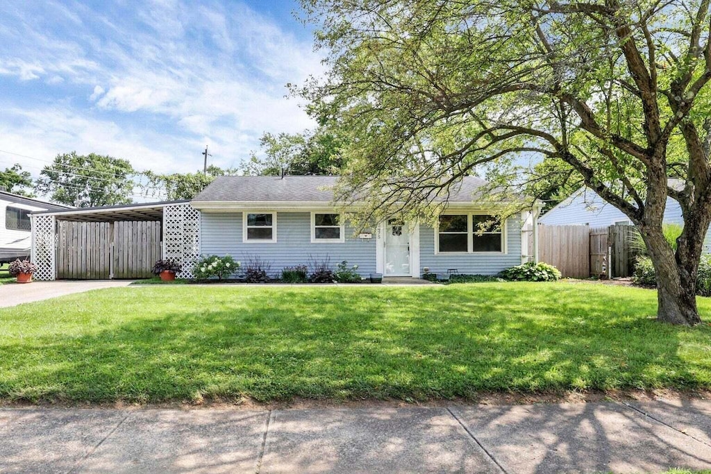 ranch-style home with a front yard and a carport