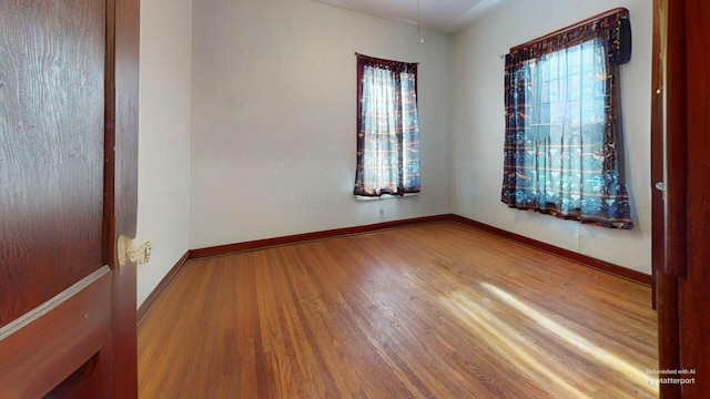 spare room featuring hardwood / wood-style floors and a healthy amount of sunlight