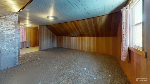 additional living space featuring wood ceiling, vaulted ceiling, and wood walls