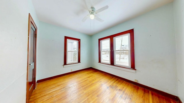 unfurnished room featuring light wood-type flooring, baseboards, and a ceiling fan