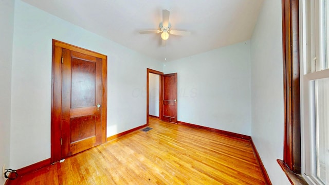 unfurnished bedroom with ceiling fan, baseboards, and wood finished floors