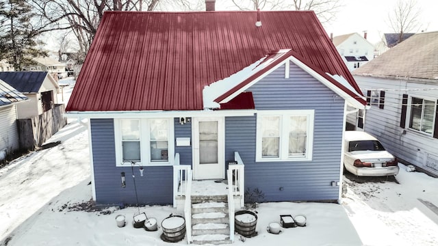 view of front of home featuring metal roof and a chimney