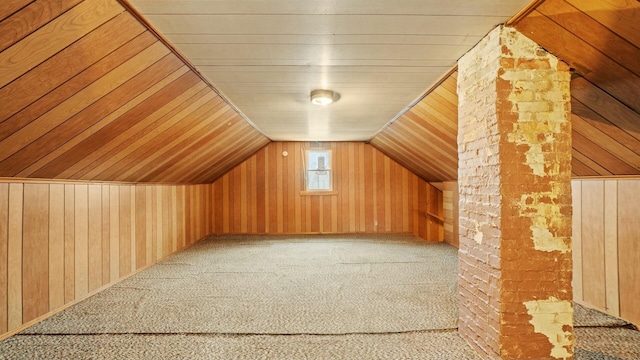 bonus room featuring vaulted ceiling, wood walls, and carpet flooring