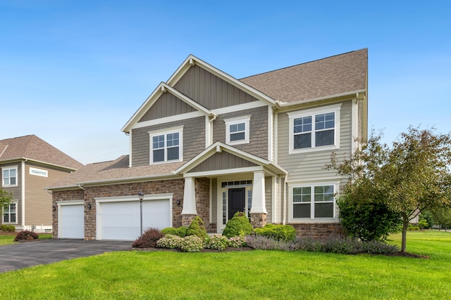 7136 Cabernet Ct, Dublin, OH 43016 - craftsman house featuring stone siding, driveway, a front yard, a garage, and a shingled roof