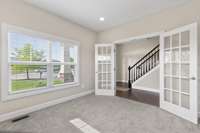 7136 Cabernet Ct, Dublin, OH 43016 - empty room featuring dark carpet, french doors, stairs, and recessed lighting