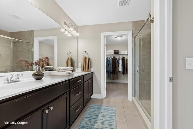 7136 Cabernet Ct, Dublin, OH 43016 - full bath featuring a walk in closet, double vanity, tile patterned floors, and a stall shower