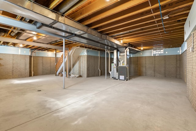 7136 Cabernet Ct, Dublin, OH 43016 - basement featuring heating unit, brick wall, and stairs