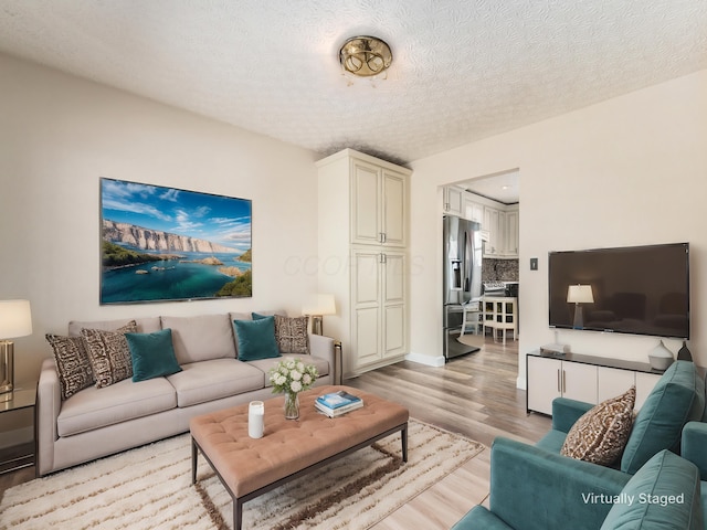 living room featuring light hardwood / wood-style floors and a textured ceiling