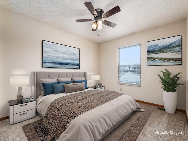 carpeted bedroom featuring a textured ceiling and ceiling fan