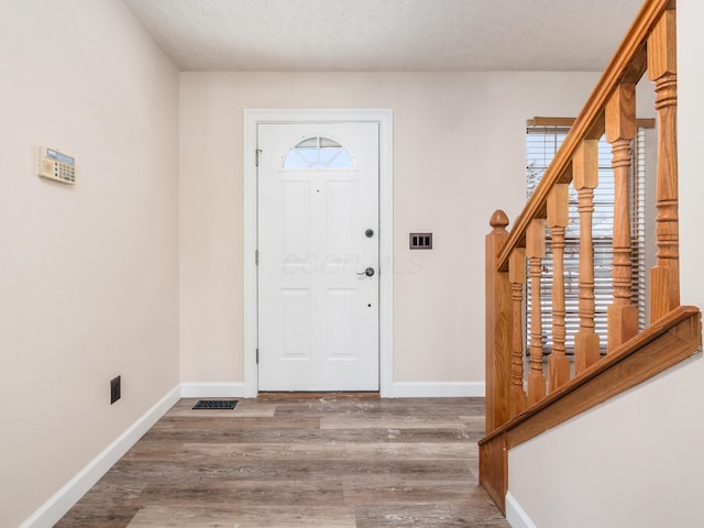 entryway with a textured ceiling and hardwood / wood-style flooring