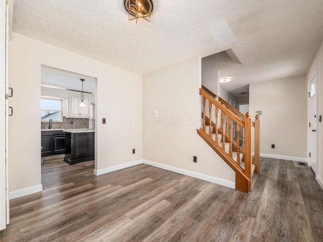 foyer entrance featuring sink, a textured ceiling, and dark hardwood / wood-style flooring