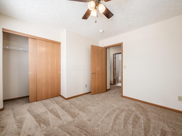 unfurnished bedroom featuring ceiling fan, a closet, light carpet, and a textured ceiling