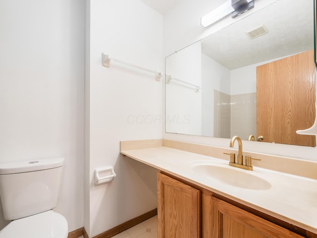 bathroom featuring toilet, vanity, and a shower