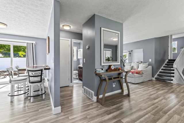 interior space featuring a textured ceiling and light hardwood / wood-style floors