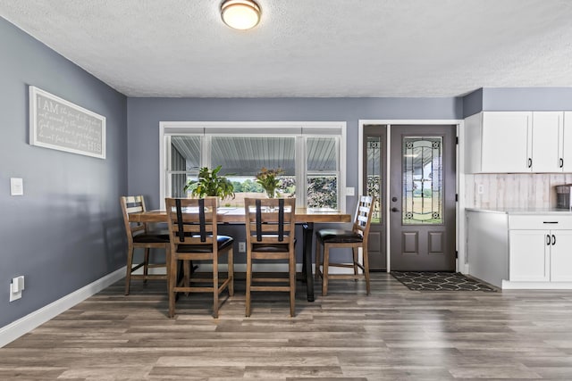 dining area with a textured ceiling and dark hardwood / wood-style floors